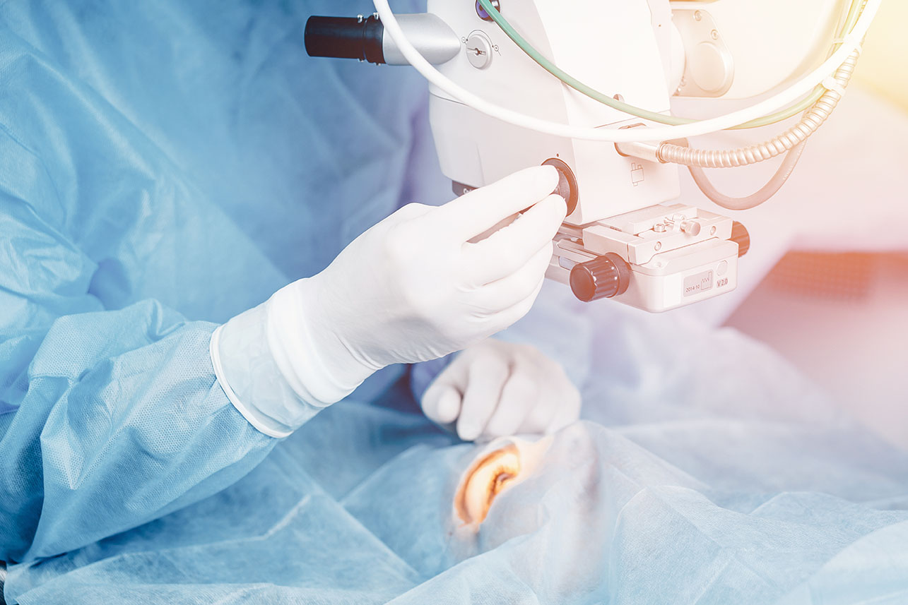 Lasik treatment. Laser vision correction. Doctor examines fundus in microscope, patient under sterile cover